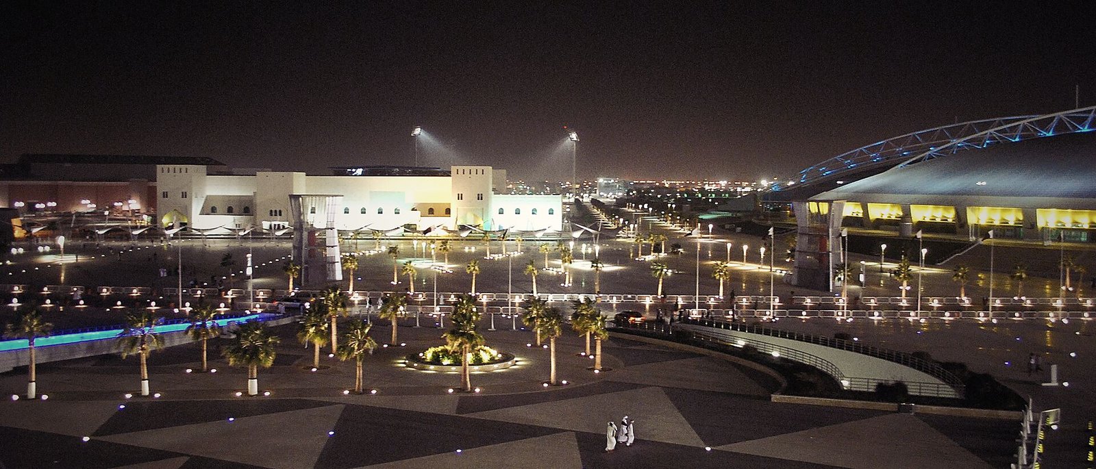 The Doha skyline lit gold and blue across the bay at night